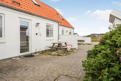 a picnic table in front of a white house at 324-Harboore-Skalvej-4-b in Harboør