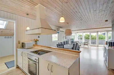 a kitchen and living room with a stove top oven at 145-Harboore-Neerlandiavej-98 in Harboør