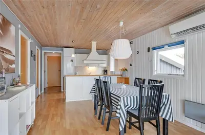 a kitchen and dining room with a table and chairs at 145-Harboore-Neerlandiavej-98 in Harboør