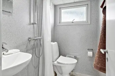 a bathroom with a toilet and a sink and a window at G103-Lemvig-Klovervej-3 in Lemvig