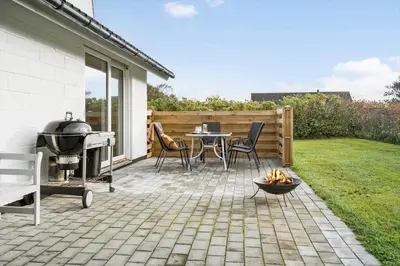 a patio with a grill and a table and chairs at G113-Lemvig-Nellikevej-13 in Lemvig