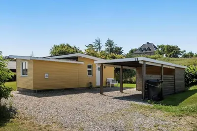 a small yellow house with a garage at G171-Lemvig-Porsevej-71 in Lemvig