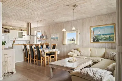 a living room with a couch and a table and a kitchen at 121-Harboore-Vejlby-Klit-173-a in Harboør