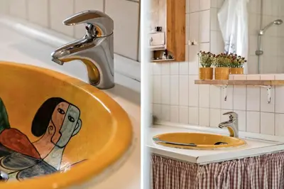 a bathroom with a sink with a painting of a man at 121-Harboore-Vejlby-Klit-173-a in Harboør