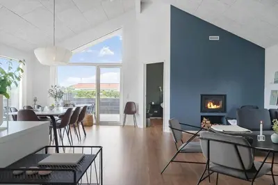 a living room with a table and chairs and a fireplace at 237-Harboore-Neerlandiavej-17 in Harboør