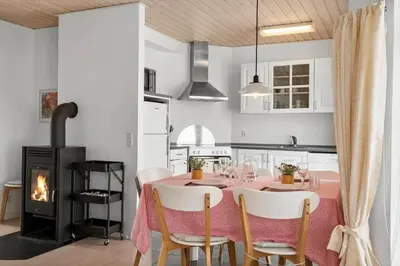 a dining room with a table and a fireplace at 325-Harboore-Skalvej-4-c in Harboør