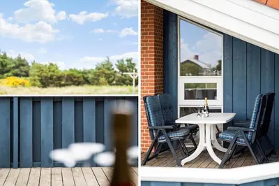 a patio with a table and chairs on a porch at 267-Harboore-Vaermlandvej-10 in Harboør