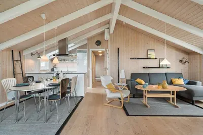 a living room and kitchen with a couch and a table at 267-Harboore-Vaermlandvej-10 in Harboør