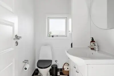 a white bathroom with a toilet and a sink at G139-Lemvig-Porsevej-39 in Lemvig