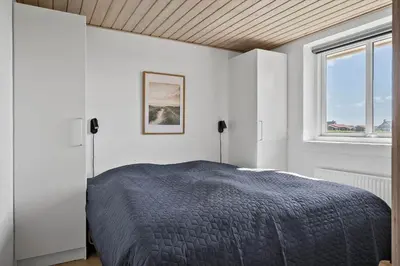 a white bedroom with a bed and a window at 305-Harboore-Arcticvej-6 in Harboør