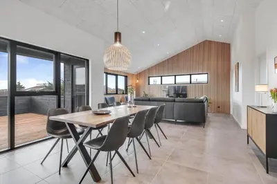 a dining room and kitchen with a table and chairs at 255-Harboore-Vejlby-Klit-37-A in Harboør