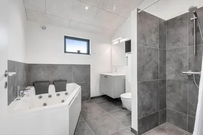 a bathroom with a tub and a shower and a toilet at 255-Harboore-Vejlby-Klit-37-A in Harboør