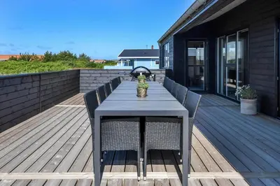 a blue table and chairs on a wooden deck at 255-Harboore-Vejlby-Klit-37-A in Harboør