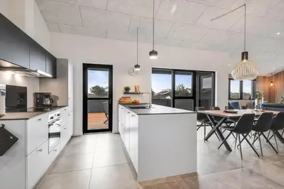a kitchen and dining room with a dining table at 255-Harboore-Vejlby-Klit-37-A in Harboør