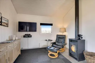 a living room with a chair and a fireplace at 100-Harboore-Vejlby-Klit-51 in Harboør