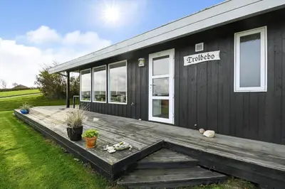 a black tiny house with a wooden deck at G230-Lemvig-Gyvelvej-30 in Lemvig