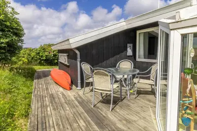 a patio with a table and chairs on a deck at G230-Lemvig-Gyvelvej-30 in Lemvig