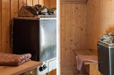 a kitchen with a stove in a wooden room at 259-Harboore-Vejlby-Klit-129 in Harboør