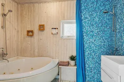 a bathroom with a tub and a toilet and a sink at 259-Harboore-Vejlby-Klit-129 in Harboør