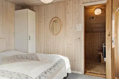 a bedroom with a bed and a wooden wall at 259-Harboore-Vejlby-Klit-129 in Harboør