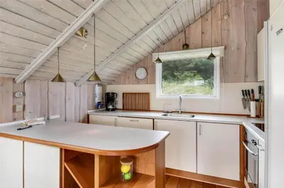 a kitchen with white cabinets and a sink and a window at 108-Harboore-Merchantvej-10-C in Harboør