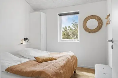 a white bedroom with a bed and a window at 375-Harboore-Gloryvej-14-A in Harboør