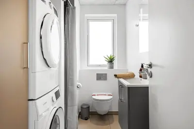 a white bathroom with a toilet and a sink at 375-Harboore-Gloryvej-14-A in Harboør
