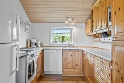 a kitchen with white appliances and wooden cabinets at G124-Lemvig-Porsevej-24 in Lemvig