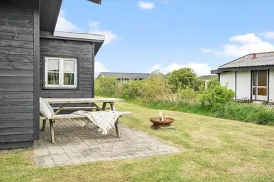 a patio with a table and a bench next to a house at G305-Lemvig-Porsevej-105 in Lemvig