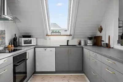 a kitchen with white cabinets and a sink and a window at 226-Harboore-Nautilusvej-5 in Harboør