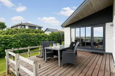 a wooden deck with a table and chairs on it at G193-Lemvig-Bellisvej-93 in Lemvig