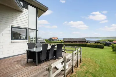 a wooden deck with a table and chairs on it at G193-Lemvig-Bellisvej-93 in Lemvig