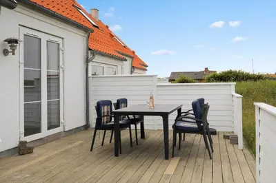 a table and chairs on a wooden deck at 323-Harboore-Skalvej-4-a in Harboør