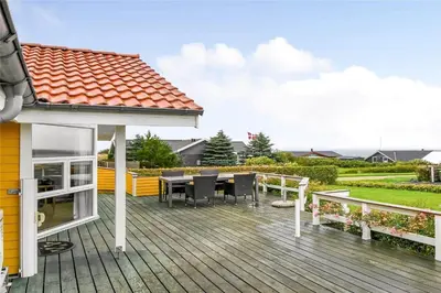 a deck with a table and chairs on a house at G131-Lemvig-Skovstjernevej-31 in Lemvig