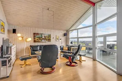 a living room with chairs and a couch and windows at G131-Lemvig-Skovstjernevej-31 in Lemvig