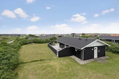 an overhead view of a black house in a field at 119-Harboore-Neerlandiavej-32 in Harboør