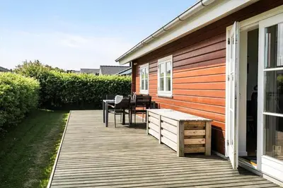a wooden deck with a table and chairs on a house at G119-Lemvig-Klovervej-19 in Lemvig