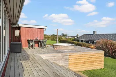 a backyard with a wooden deck with a table at G281-Lemvig-Syrenvej-81 in Lemvig
