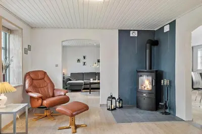 a living room with a chair and a fireplace at 369-Lemvig-Klostervej-39 in Lemvig