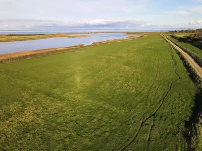 an aerial view of a green field next to a river at 369-Lemvig-Klostervej-39 in Lemvig