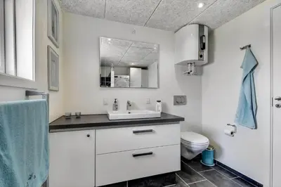 a white bathroom with a sink and a toilet at 102-Harboore-Vejlby-Klit-21 in Harboør