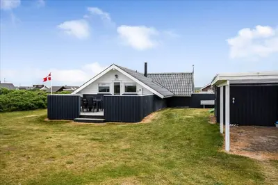 a house with a fence in front of a yard at 209-Harboore-Vejlby-Klit-291-A in Harboør