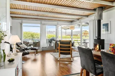 a living room with a fireplace and a table and chairs at G120-Lemvig-Gyvelvej-20 in Lemvig