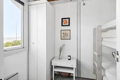 a white bedroom with a table and a window at G120-Lemvig-Gyvelvej-20 in Lemvig