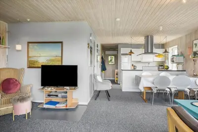 a living room with a television and a dining room at 134-Harboore-Karolinevej-8 in Harboør