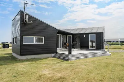 a black house with a porch and a yard at 227-Harboore-Bjergehusvej-4 in Harboør