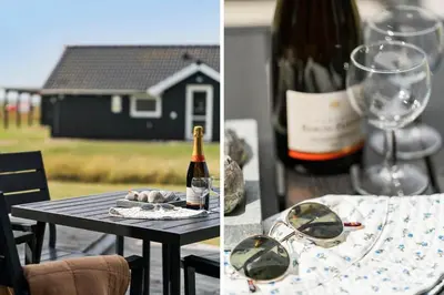 a table with a bottle of wine and a glass at 227-Harboore-Bjergehusvej-4 in Harboør