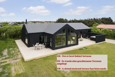 a black modular house with a large deck at 299-Harboore-Neerlandiavej-108 in Harboør
