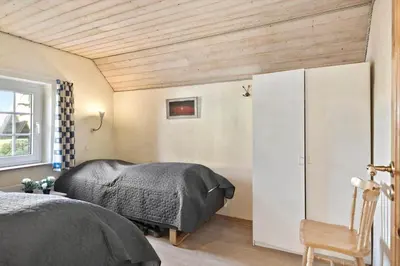 a bedroom with a bed and a white cabinet at 377-Harboore-Fourmivej-56 in Harboør