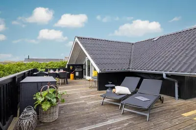a deck with chairs and tables on a roof at 804-Harboore-Neerlandiavej-214 in Harboør